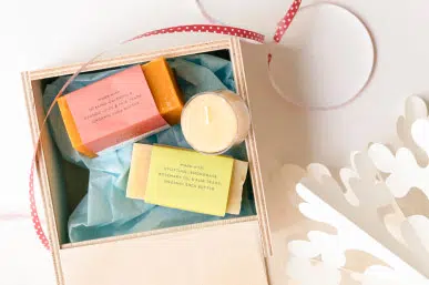 a wooden box with a some candles and soaps inside